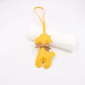 Détail macro du charm girafe en cuir jaune avec nœud marron et couture précise - Cordon Nœud Girafe / Jaune