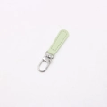 Detail view of light green leather zipper pull with silver metal lobster clasp - Matcha Green