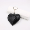 Dettaglio del portachiavi a cuore in pelle nera con trama a serpente goffrata - Nero