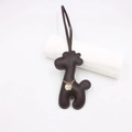 Close-up of deep brown leather animal charm with golden chain and metal logo tag - Dark Brown