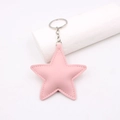 Pink star-shaped leather keychain with silver metal ring on white background stand - Pink