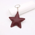 Macro detail of star-shaped lychee grain leather keychain in burgundy with silver ring - Burgundy