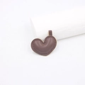 Dettaglio di un ciondolo a cuore in pelle marrone scuro con cuciture fini e occhiello di fissaggio - Marrone