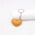 Nahaufnahme gelber Herz-Schlüsselanhänger aus Leder mit Metallring und Ziernaht - Orange