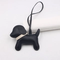 Close-up of black leather puppy bag charm with white collar and fine stitching details - Black - Beige Collar