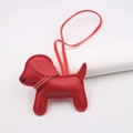 Close-up of red leather puppy bag charm with white stitching and hanging strap detail - Red - Red Collar