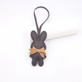 Dunkelbrauner Leder-Hasenanhänger mit hellbrauner Schleife und passendem Trageband - Braun