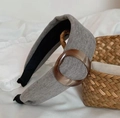 Detailed texture of gray knitted headband with amber resin buckle on soft background - Gray