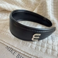Detail of black leather headband featuring a rhinestone E letter and handmade label - Rhinestone Letter Decoration (E) / Black