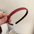 Detailaufnahme des glänzenden dunkelroten PU-Leder-Haarreifs mit rutschfestem Futter - Ancora Rot (1cm Breite)
