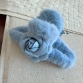 Détail de la pince à cheveux camélia bleu clair en peluche avec texture fausse fourrure - Bleu