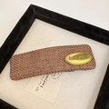Macro view of a large brown woven hair claw clip with a handmade gold metal plate - Square Oval Coffee (D-4741-5)