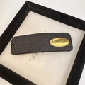 Detail of black woven rectangular hair claw clip with a golden handmade metal plate - Square Oval Black (D-4741-6)