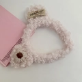 Detailopname van witte pluche berenhaarband met zachte fleece textuur en geweven bloem - Roze