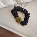 Dettaglio di un elastico per capelli in seta nera con ciondolo a smiley dorato su lino - Stile Faccina Sorridente Nera (A-3045-2)