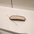 Détail d'une pince à cheveux en acétate crème avec strass colorés et bordure noire - Pince à Cheveux Blanc Cassé Colorée