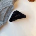 Detail einer flauschigen schwarzen hohlen Dreieck-Haarklammer mit Kunstfell-Textur - Schwarz