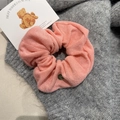 Close-up of pink scrunchie with soft towel fabric texture and golden metal tag detail - Light Pink Scrunchie