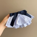 Detailed view of blue striped pleated hair clip with navy satin bow accessory - Blue