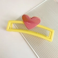 Détail d'une pince à cheveux jaune rectangulaire avec un cœur rose sur une surface en verre - Jaune et Rose (D-4266-9)