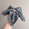 Dettaglio dell'elastico per capelli in tessuto grigio a righe con etichetta dorata - Elastico per Capelli in Tessuto con Fiocco (D-5926-4)