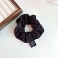 Elegant large black scrunchie with textured fabric and white camellia floral tag - Black