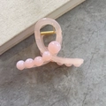 Pinza de pelo de acrílico rosa gelatina con perlas sobre superficie de piedra - Rosa