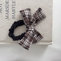 Detail of a brown plaid bow scrunchie with tiny bow patterns on a linen book cover - Coffee Bow Scrunchie