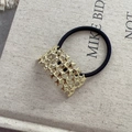 Vue détaillée d'un chouchou noir avec accessoire métallique doré à motif d'étoiles - Style Étoile Ajouré Doré (D-5421-6)