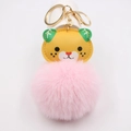 Detail of cartoon tiger keychain featuring a large fluffy pink pompom and gold metal ring - Gold Keychain / Pink