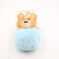 Detailed close-up of a blue faux fur pompom keychain with a cute bear head pendant - Gold Keychain / Light Blue