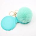 Detail of mint green plush pom pom keychain with a matching round mirror protective cover - Mint Green
