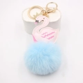 Porte-clés cygne en peluche avec pompon bleu clair et cygne rose sur support de vente - Bleu clair