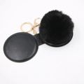 Detail view of black faux fur pompom keychain with golden metal clasp on white background - Black