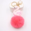 Porte-clés cygne rose avec couronne dorée et pompon en peluche sur support blanc - Rouge pastèque