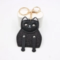 Cute black leather cat keychain with glitter body and gold hardware on a white stand - Witch Black Cat