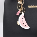 Ciondolo per borsa a forma di anguria in pelle con nappe rosa su borsa nera elegante - Anguria
