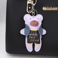 Detail eines lila Lederbären-Anhängers mit schwarzem Shirt an einer strukturierten Tasche - Taro-Lila
