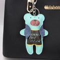 Detail eines mintgrünen Bären-Anhänger aus Leder mit blauer Weste an schwarzer Tasche - Grün