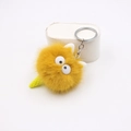 Dettaglio del portachiavi in peluche giallo con grandi occhi bianchi e catena d'argento - Arancione