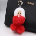Detail of red and white sleeping doll pom-pom pendant hanging on a black leather handbag - Bright Red