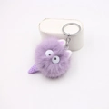 Dettaglio macro di un ciondolo mostro di peluche viola con pelliccia e portachiavi - Viola Taro