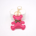 Detail eines rosa Leder-Bären-Schlüsselanhängers mit rot-grünem Karo-Schleifen-Charm - Bär Anhänger / Rosenrot