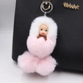 Pink and white fluffy doll keychain accessory hanging on a black leather handbag - Light Pink