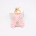 Detail of a pink leather bear keychain with gold clasp and engraved silver charm pendant - Pink