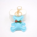 Close-up of light blue leather teddy bear keychain with British plaid bow and gold metal clasp - Bear Charm / Blue