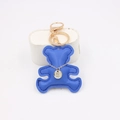 Detail view of royal blue faux leather bear keychain with golden alloy ring and mini pendant - Sapphire Blue