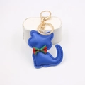 Dettaglio di un portachiavi a gatto in pelle blu con fiocco a quadri e gancio dorato - Blu Zaffiro