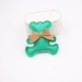 Detailed view of handmade green leather bear pendant with fine stitching and brown bow charm - Green