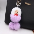 Cute sleeping doll keychain with purple and white faux fur pompom on a black leather bag - Taro Purple